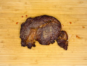 Seared ribeye steak on a wooden cutting board