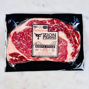 Packaged ribeye steak from Zion Farms on a marble surface