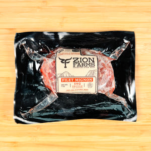 Packaged filet mignon from Zion Farms on a wooden surface