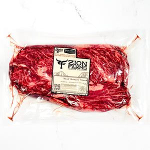 Packaged beef hanger steak with Zion Farms label on a white background