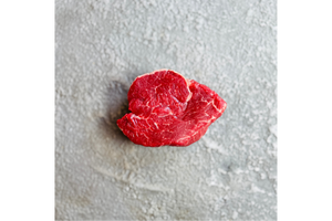 Raw piece of meat on a textured gray surface