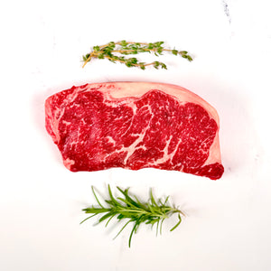 Raw steak with thyme on a white background