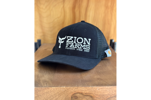 Black cap with 'Zion Farms' logo on a wooden surface