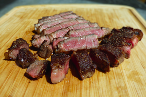 Sliced steak on a wooden cutting board