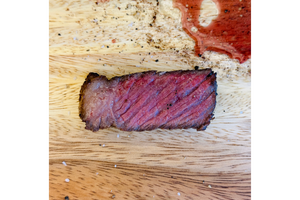 Sliced piece of smoked meat on a wooden cutting board